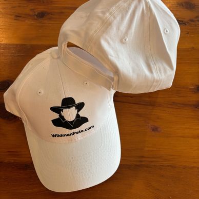 Two white caps, one with a WildmanPete.com logo and cowboy silhouette.
