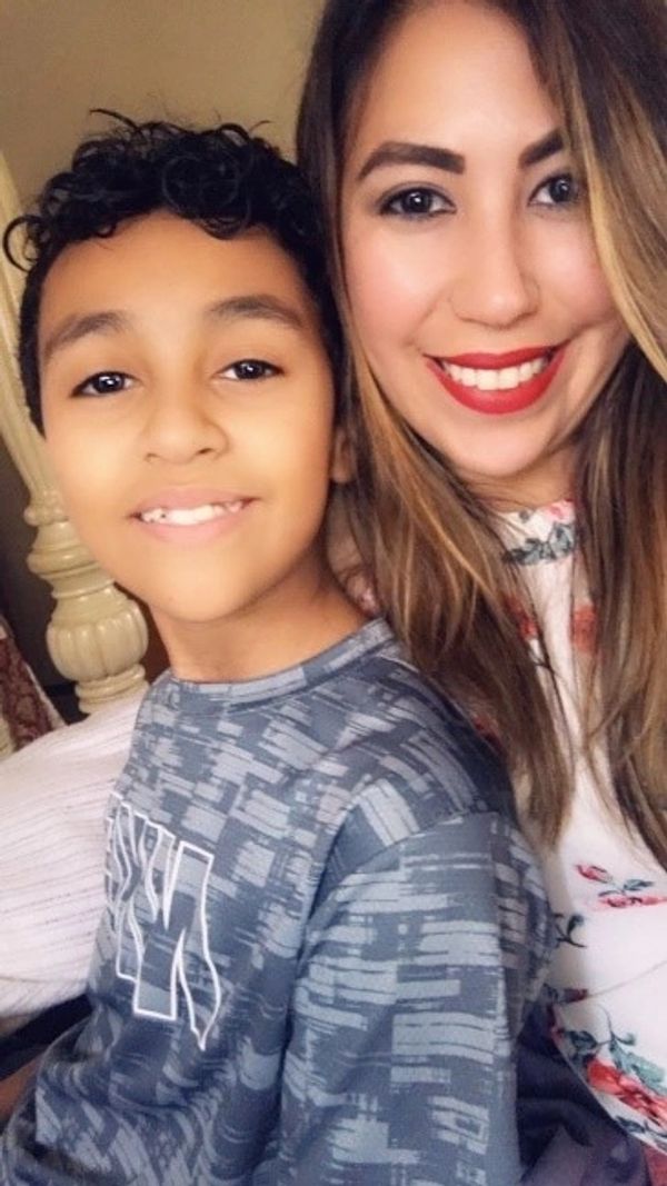 Smiling woman and boy taking a selfie indoors.