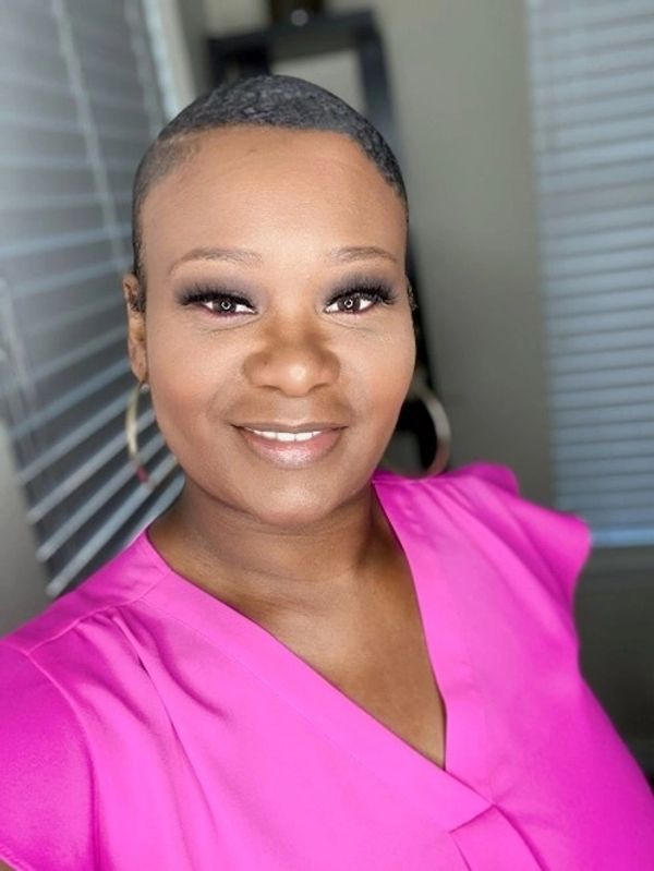 Smiling woman in a bright pink top.