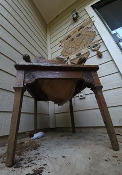 Old wooden table with a cat lying underneath.