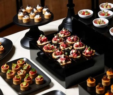 Assorted gourmet appetizers on black serving trays.