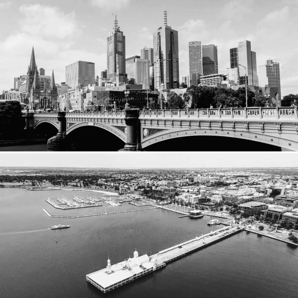 Black and white cityscape with a bridge and waterfront marina.