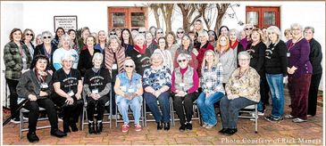 Group photo of women gathered outdoors, smiling and posing together.