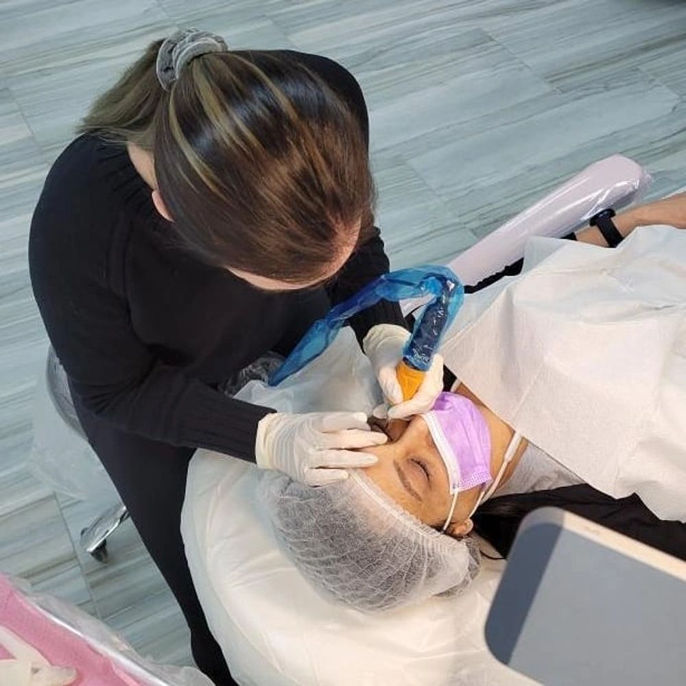 Photo of certified Permanent Makeup Artist performing cosmetic tattoo eyeliner lash line enhancement