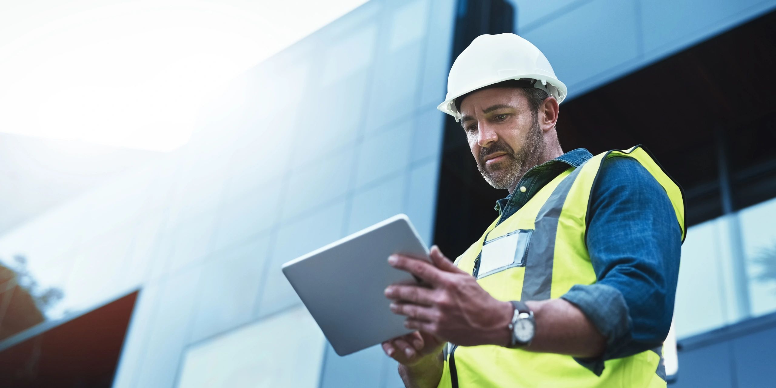 Construction worker using a tablet on site.