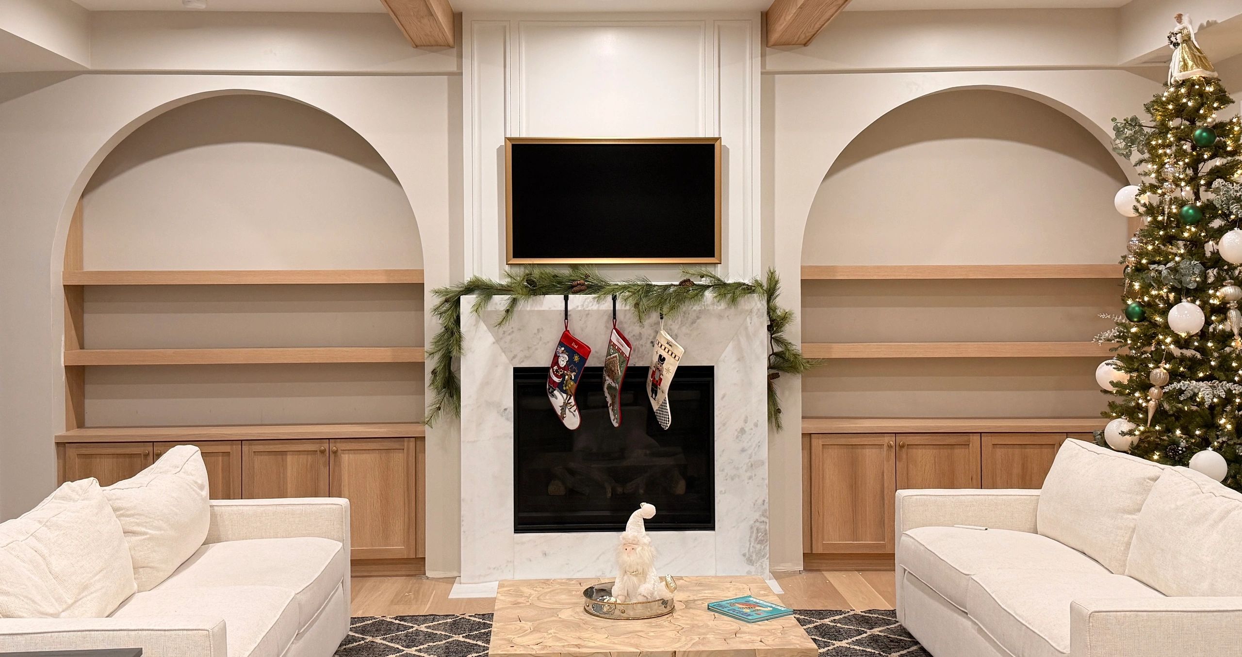 Cozy modern living room with Christmas decor and a decorated tree.