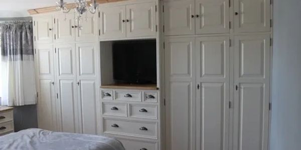 Freestanding full doors and top boxes with Tv niche custom bank of drawers painted creamy white 