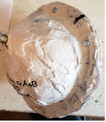 Hard outer mold with pour spout plug visible.