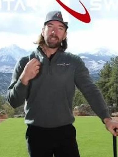 Man in casual golf attire holding a golf club outdoors.