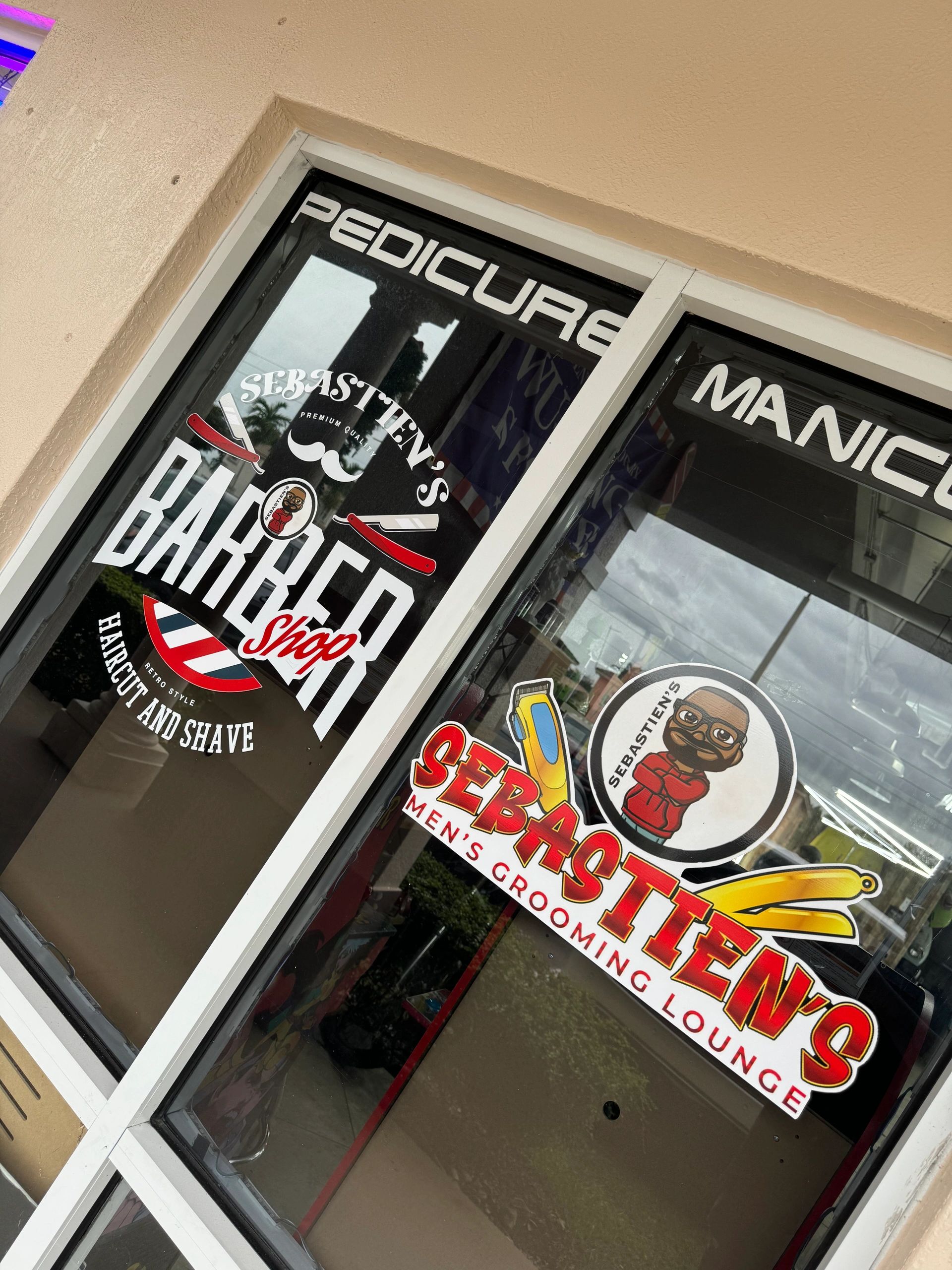 Window signage for Sebastien's Barbershop and Men's Grooming Lounge.