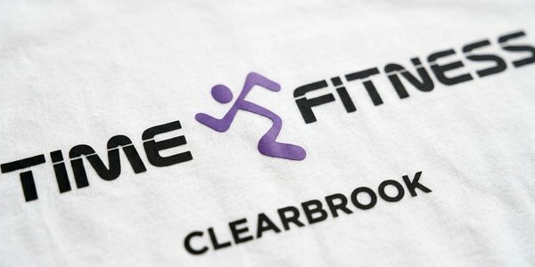 Close-up of a Time Fitness Clearbrook logo on white fabric.