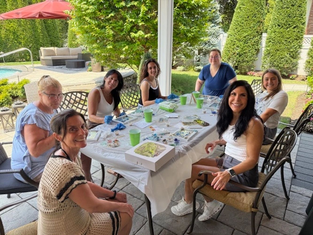 Group of women enjoying a craft session outdoors.