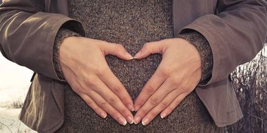 Heart hand over pregnancy bump