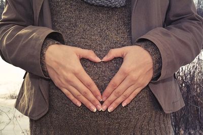hand-in-heart-shape-over-pregnanct-bump