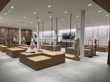 Luxury remodeled Alo store with minimalist style, wooden platforms and modern lighting design.