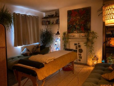 Cozy massage room with warm lighting and plants.