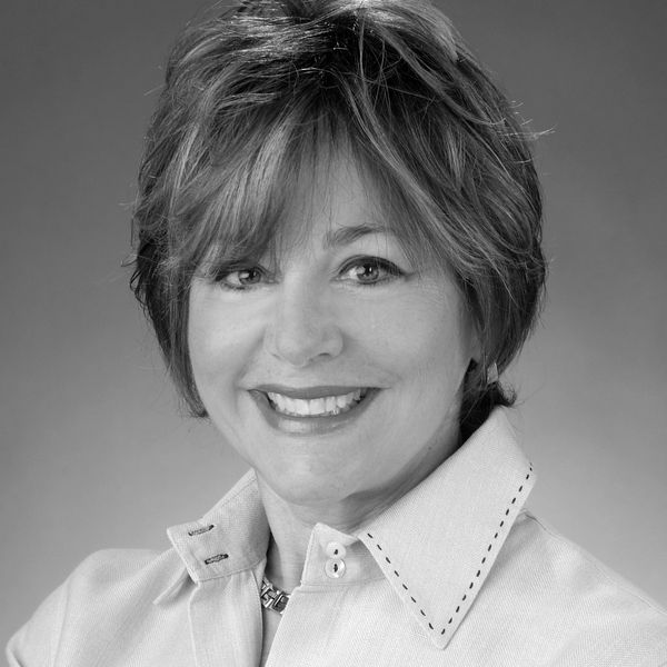 Smiling woman with short hair in a collared shirt.