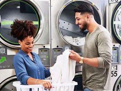 Two people doing laundry at Mary’s Laundromart.