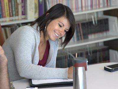 Two people studying together at a table in a library.