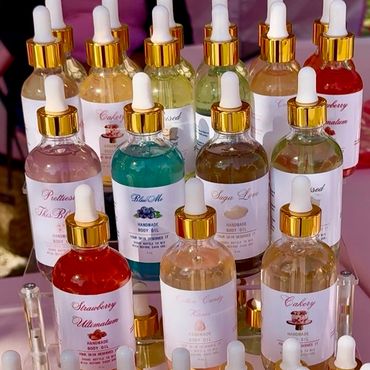 Assorted handmade body oils in glass bottles with gold droppers.