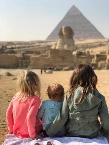 Three sisters looking at The Great Pyramids of Giza in Egypt