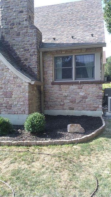 Stone house exterior with a garden bed and bushes. Pennsylvania