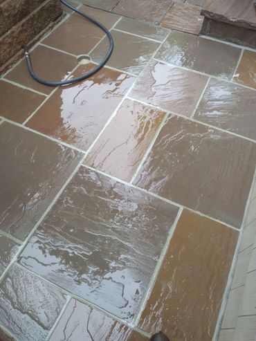 Wet stone patio with a black garden hose on the corner.
Lake harmony Pa