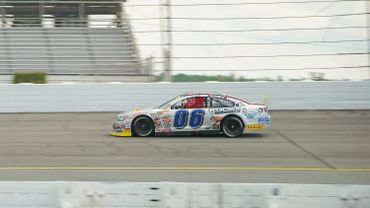 Race car number 06 speeding on a racetrack with sponsor logos.