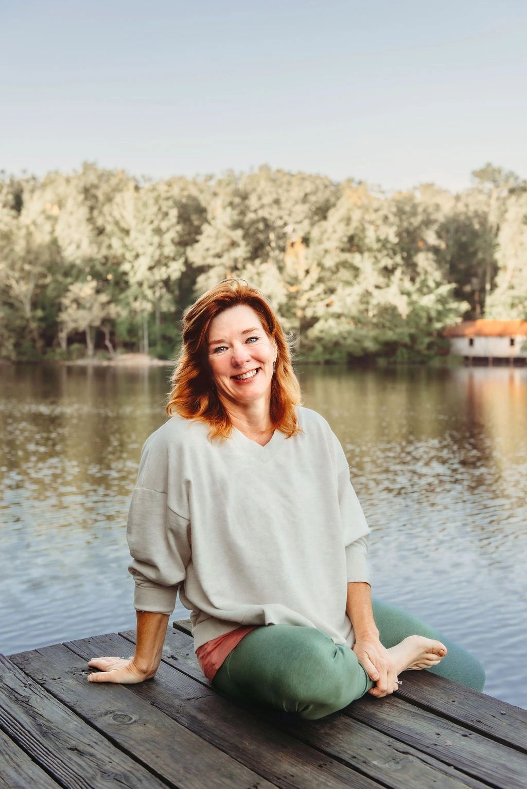 Theresa  Kuhn Sitting joyfully on a dock on an autum day feeling the energies around her .