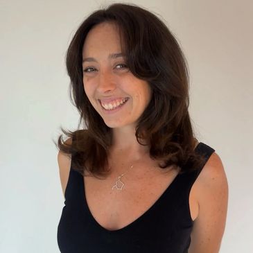 Woman with shoulder-length dark hair smiling.