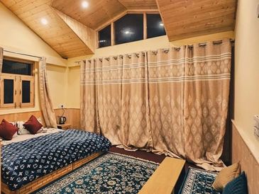 Cozy wooden bedroom with patterned curtains and rugs.