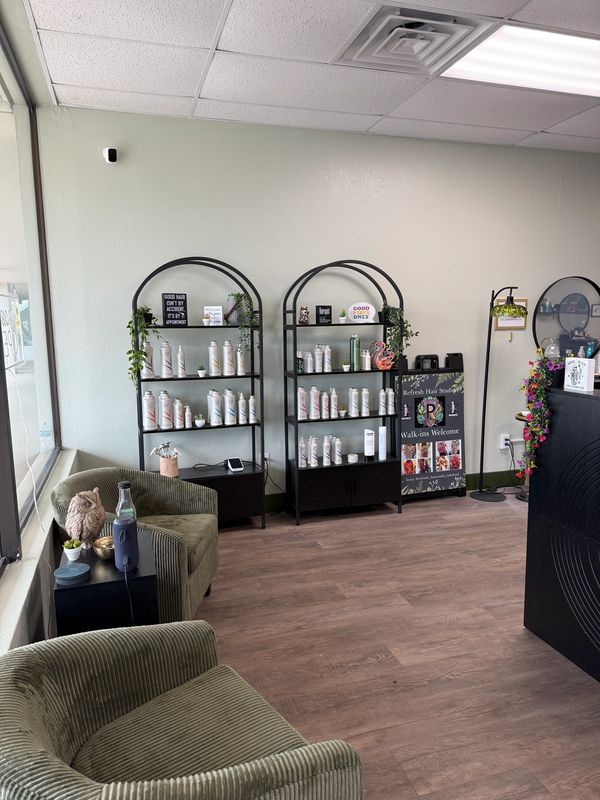 Cozy hair salon waiting area with product shelves and comfortable chairs.