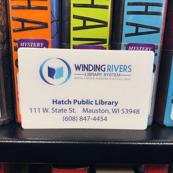 Winding Rivers Library Card in front of mystery books on bookshelf