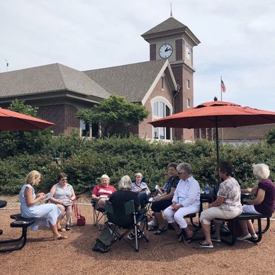 Group of people reading on the patio at Hatch Public Library