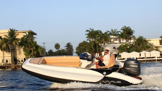 Man steering a small motorboat on water.
