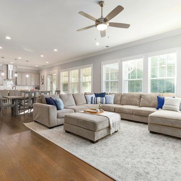 Spacious living area with large sectional sofa and adjacent kitchen.