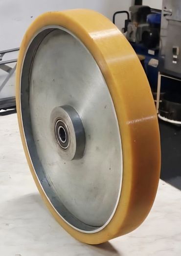 Close-up of a large industrial wheel with a yellow outer rim.