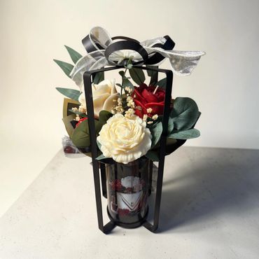 Black metal bow vase with red and ivory roses with greenery and purse with heels label