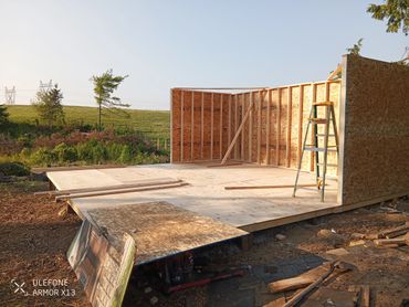 Wooden framework of a building under construction in a rural area.