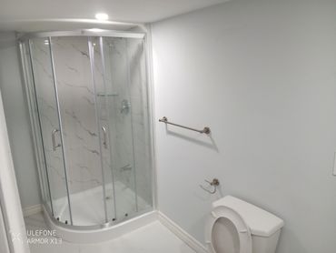 Modern bathroom with glass shower and toilet.
