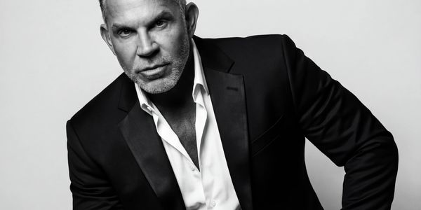 Black and white portrait of a confident man in a suit.