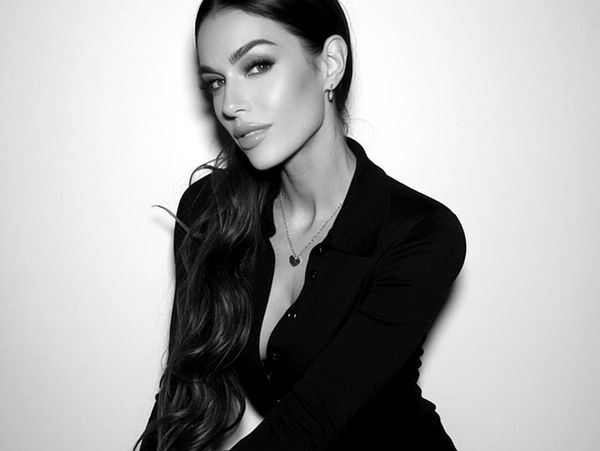 Black and white portrait of a woman with long hair and elegant jewelry.