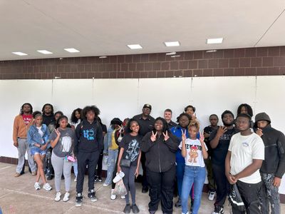 Group of diverse young people posing in front of a whiteboard.
