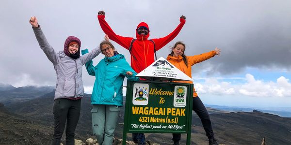 Four hikers celebrate at Wagagai Peak, the highest point on Mt. Elgon.