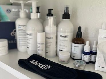 A collection of Medi skincare products arranged on a white shelf.
