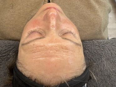 Person lying down with eyes closed, wearing a brown sweater and black headband.