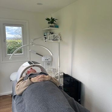Person receiving a facial treatment in a clean, bright room.