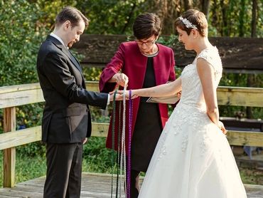 Couple participates in a handfasting ceremony at their outdoor Ontario elopement.