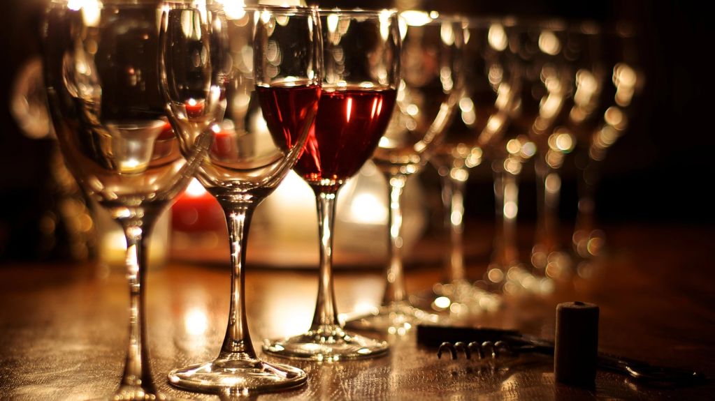 Copas de vino alineadas con luz tenue.
