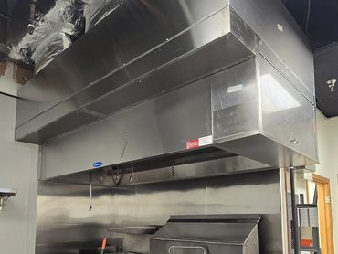 Industrial kitchen with cooking equipment and supplies.